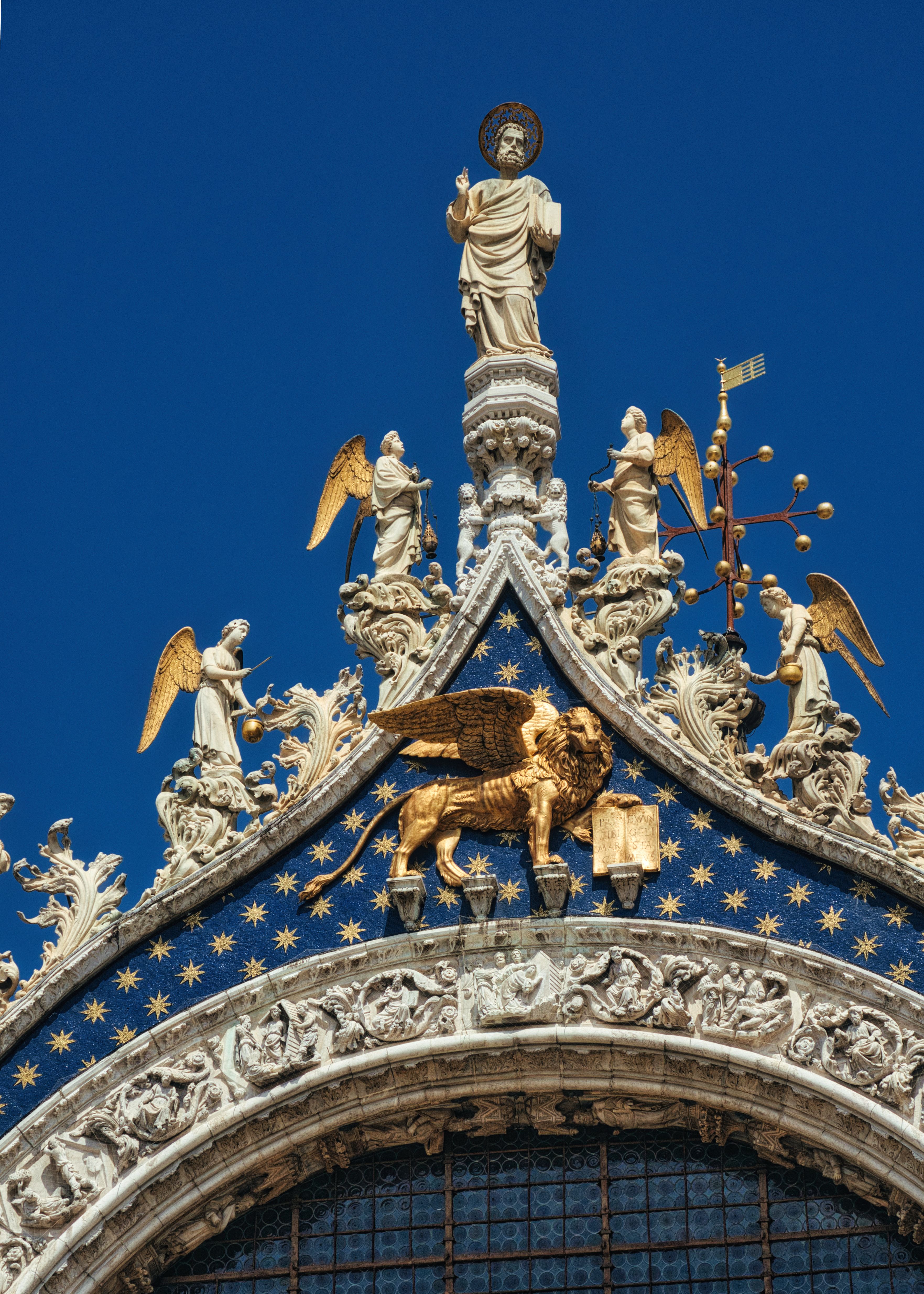 Detail of St. Mark's Basilica rooftop sculptures in Venice, showcasing intricate religious artistry.
