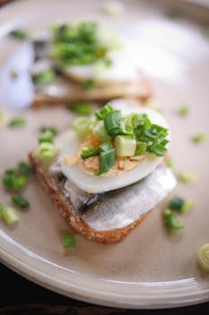 Appetizing smoked fish and egg sandwich with fresh herbs on a plate, perfect for breakfast or brunch.