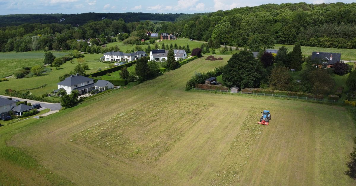 Scenic aerial view of farm fields and houses in Grez-Doiceau, Belgium during summer.