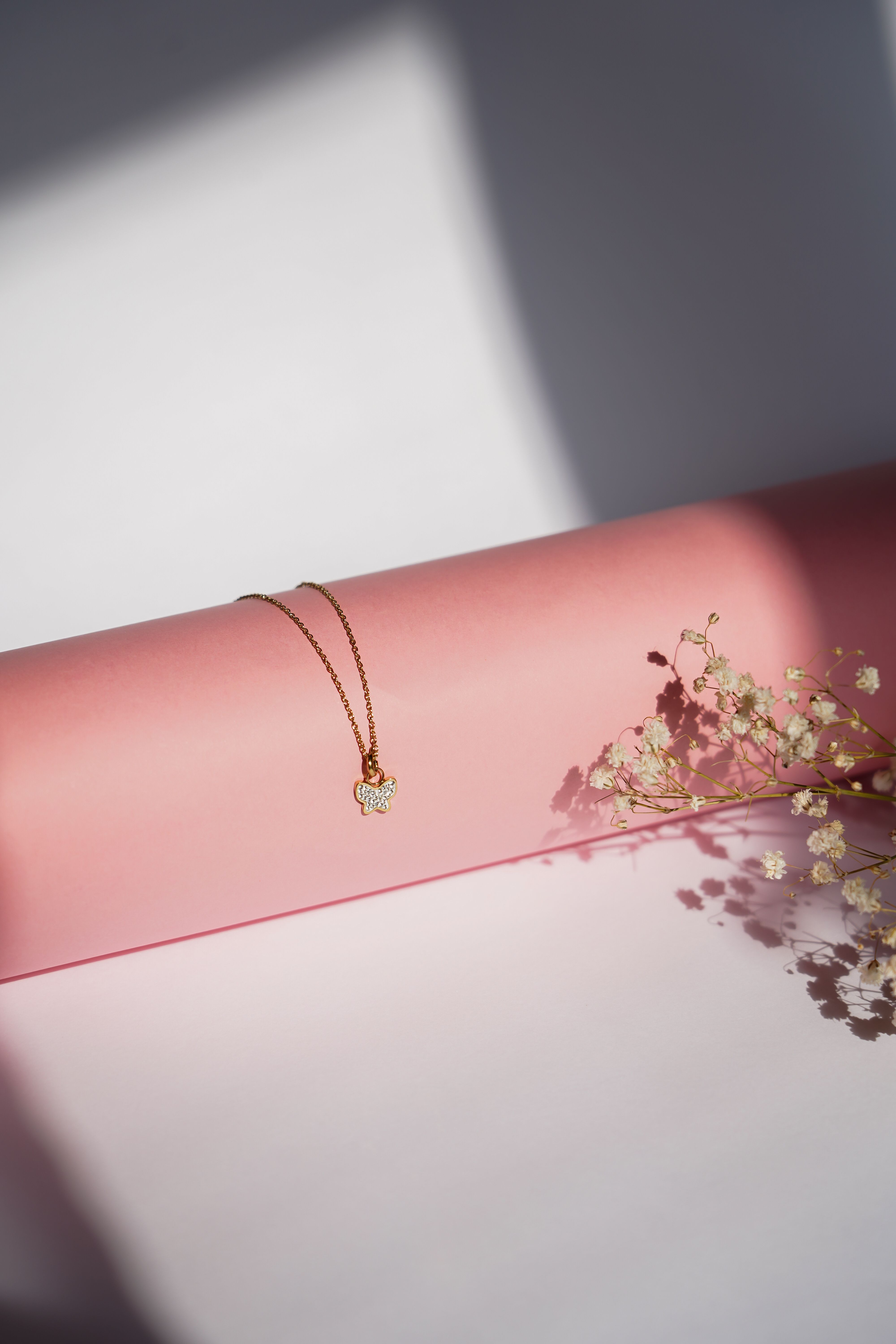 Filo chain necklace in 14k gold laid on a soft surface