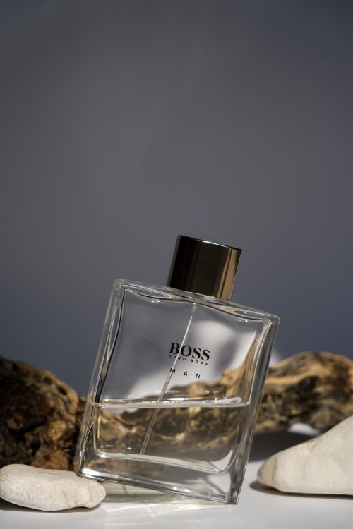 Free Stylish cologne bottle surrounded by natural stones and wood. Stock Photo