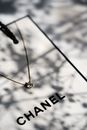 Delicate necklace on a Chanel gift box with soft shadows creating a luxurious feel.
