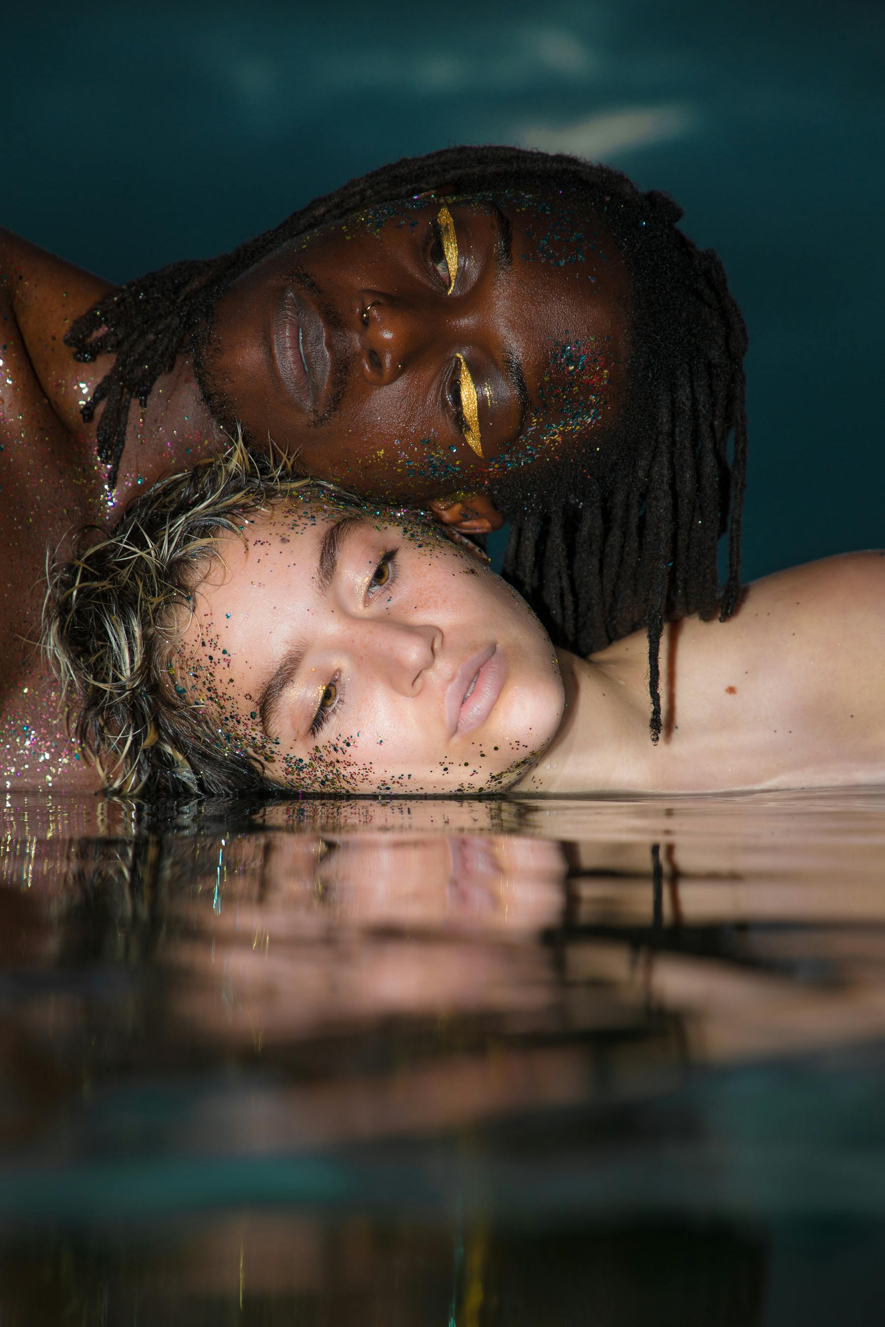 artistic photo of a young man and woman posing in the water