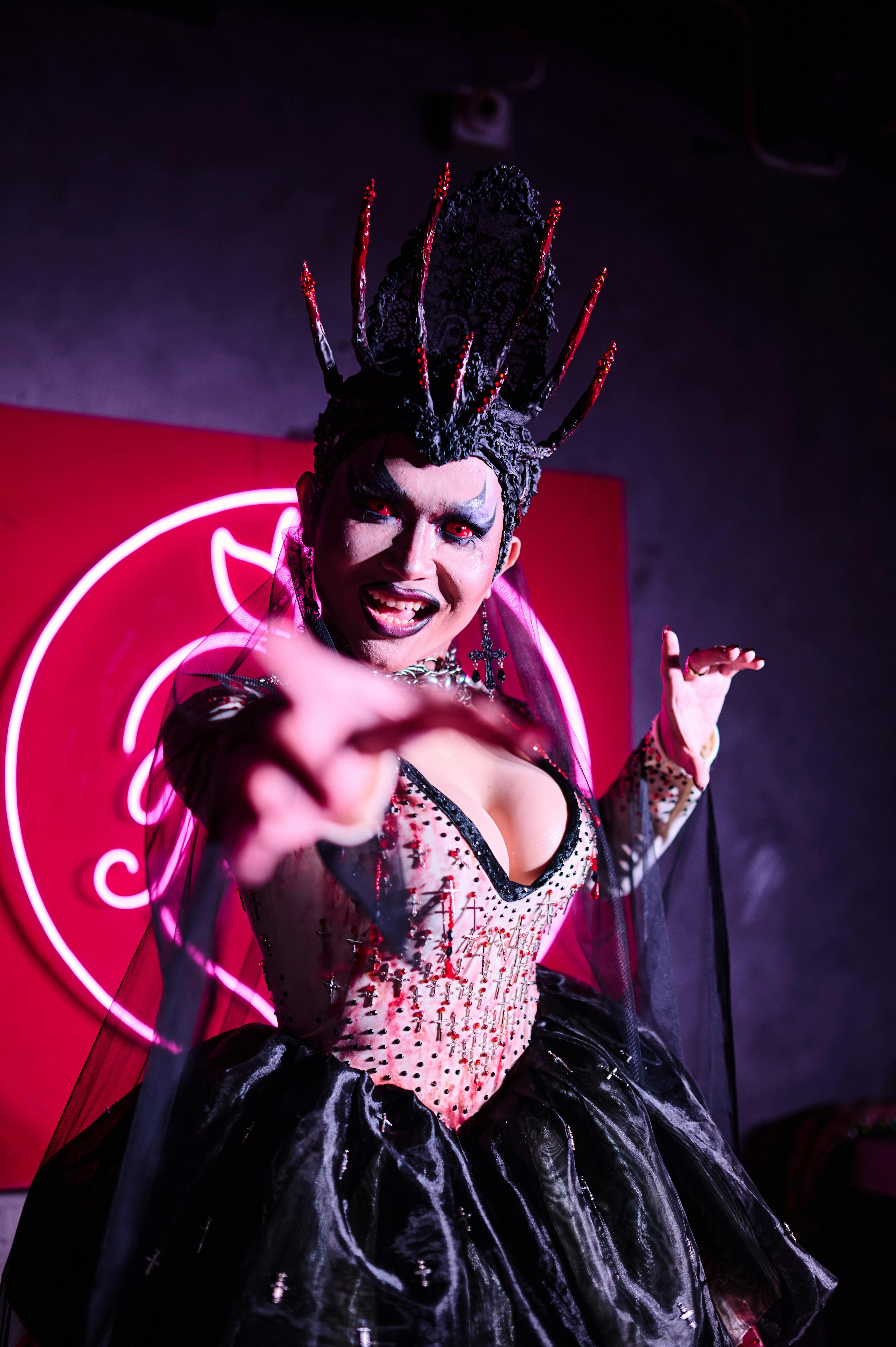 a woman in a costume with a red light behind her