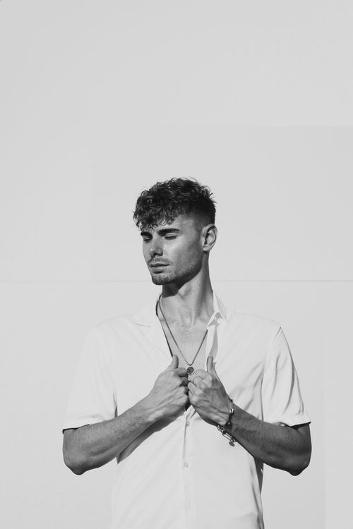 Free Black and white portrait of a fashionable young man looking pensive. Stock Photo