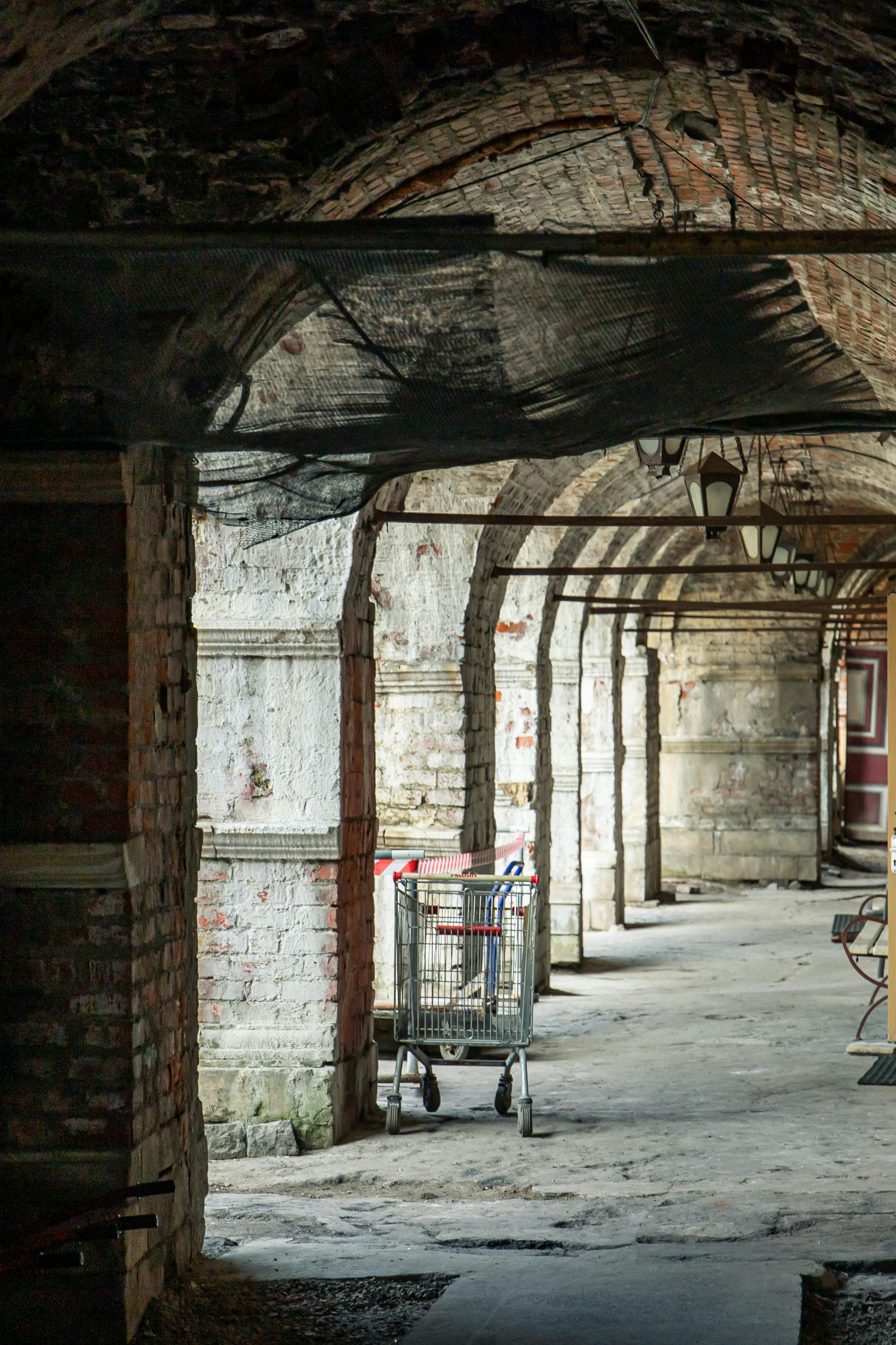 a tunnel with a brick wall and a cart