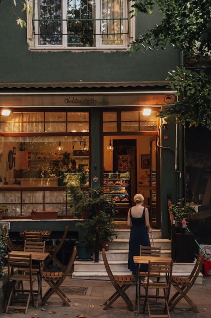 Inviting outdoor bistro with wooden furniture and warm lighting at dusk.