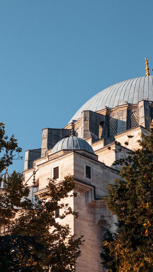 Free A beautiful ancient dome structure with intricate details and tree views under a clear sky. Stock Photo