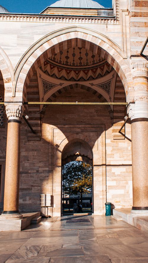 Free Explore the stunning architectural details of this historic archway bathed in sunlight. Stock Photo