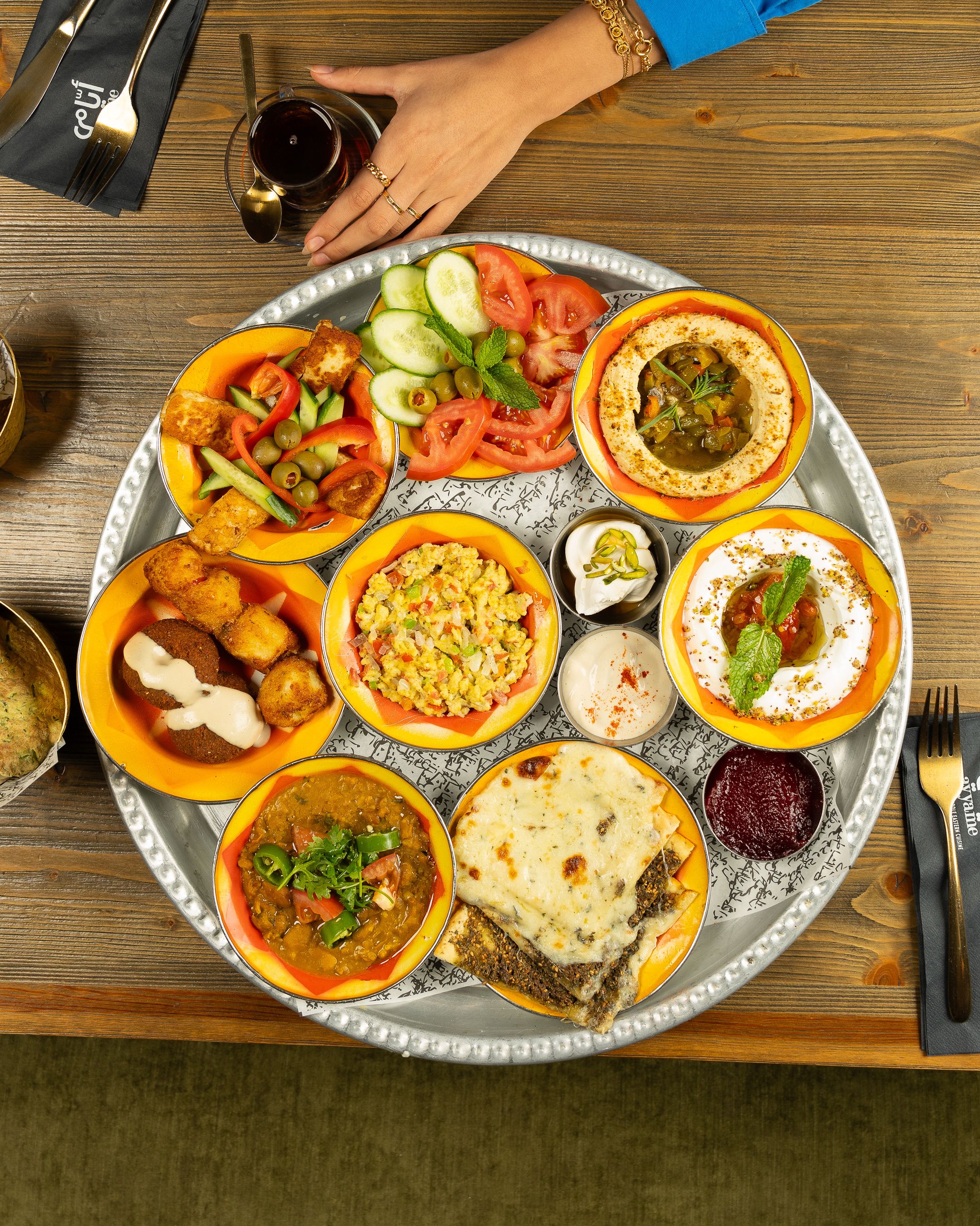 A colorful assortment of traditional Middle Eastern dishes served on a rustic wooden table. Perfect for cultural cuisine enthusiasts.