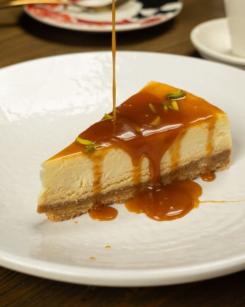 Free A tempting slice of cheesecake topped with a rich caramel drizzle and garnished with pistachios. Stock Photo
