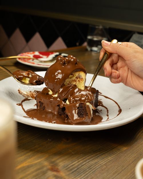 Free Decadent chocolate fudge dessert topped with creamy vanilla ice cream, served on a plate. Stock Photo