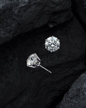 黑色宝石纹理上，奢华钻石耳环的特写尽显优雅