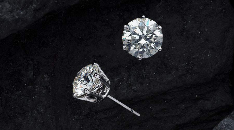 Boucles d'oreilles puces en plaqué or et zircons posées en gros plan
