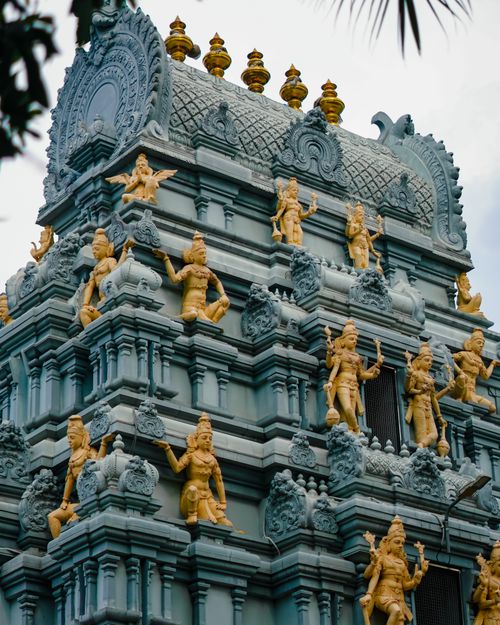 Free Detailed view of a traditional Hindu temple adorned with sculptures in vibrant colors, showcasing religious art. Stock Photo