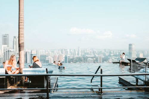 Free Experience relaxation at a stunning rooftop infinity pool with a panoramic cityscape view. Stock Photo