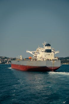 A giant oil tanker sails through the blue sea, indicating the maritime transportation industry.