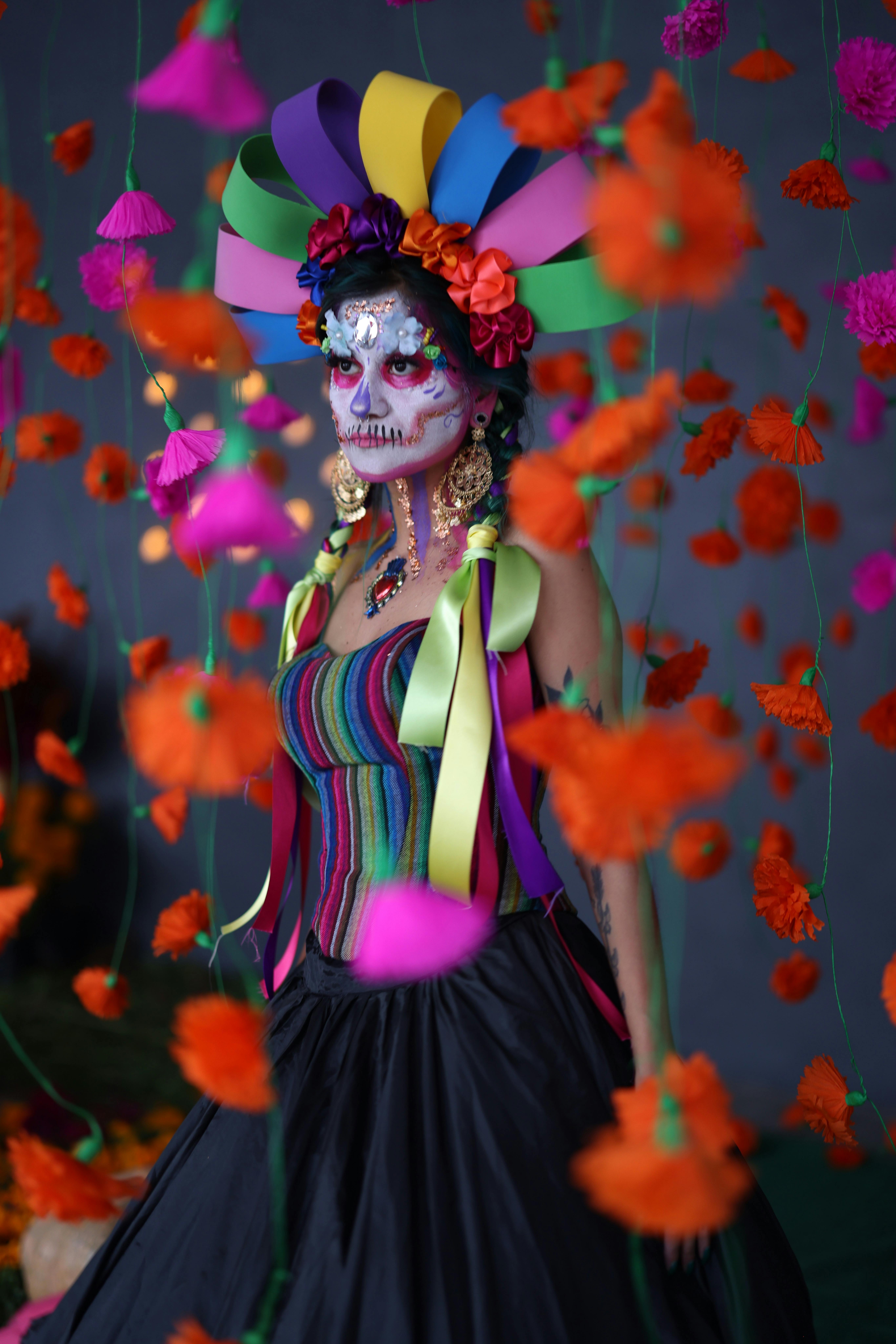 Colorful Day of the Dead costume with floral decorations and face paint.