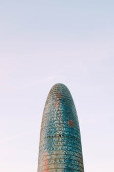 Stunning view of Torre Glòries tower standing tall against a clear sky, showcasing modern architecture.