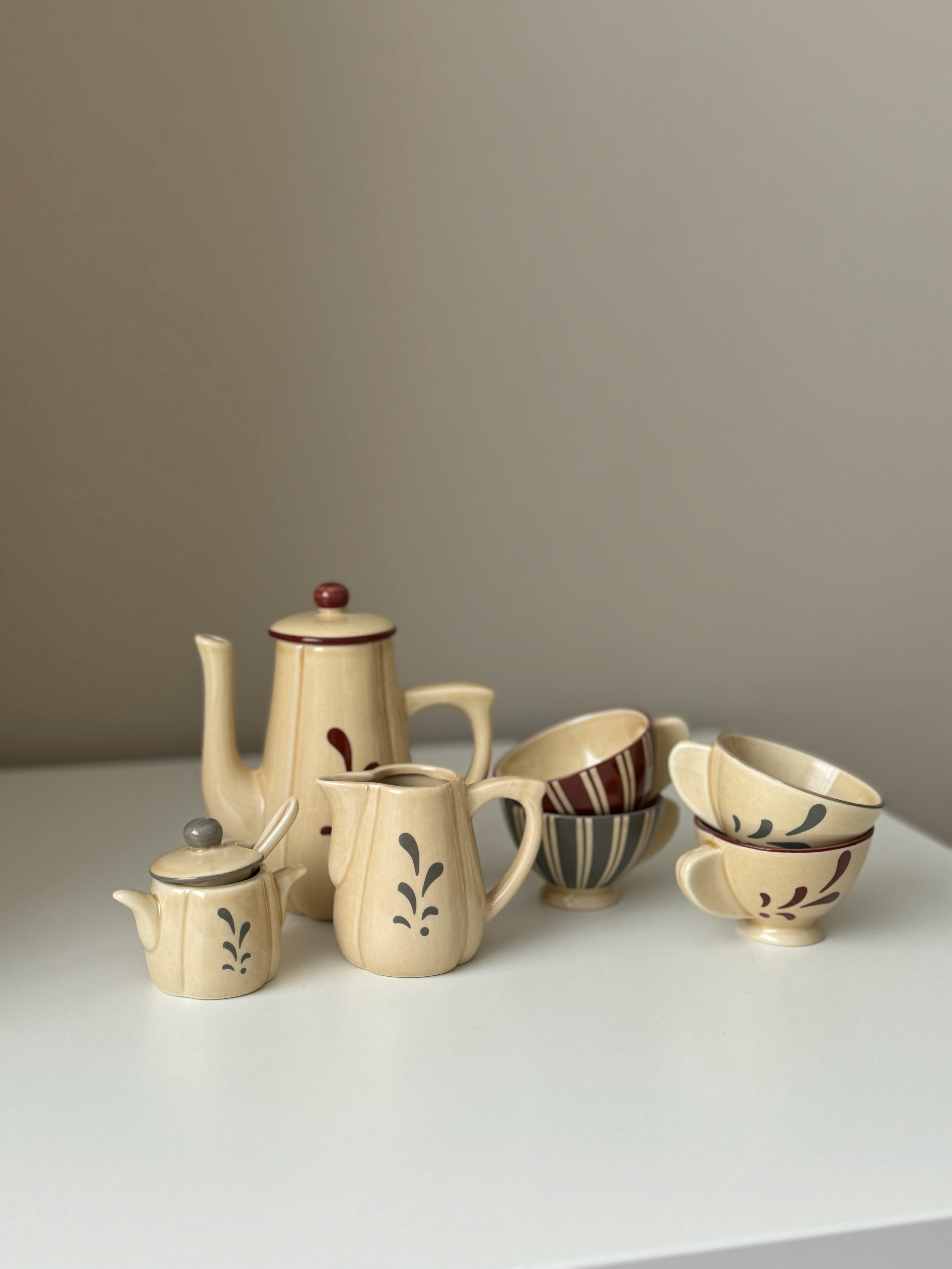 Charming vintage porcelain tea set with intricate patterns displayed on a white table, ideal for kitchens or decor.