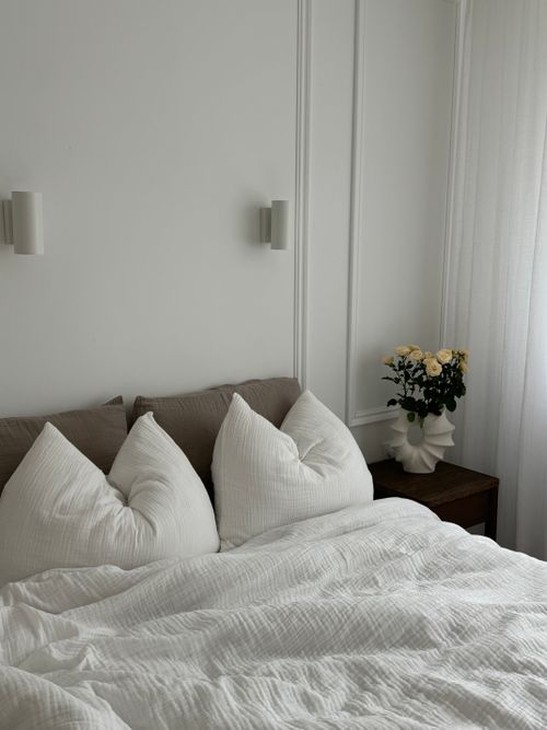 Free Elegant bedroom interior with white pillows and flowers, evoking tranquility. Stock Photo