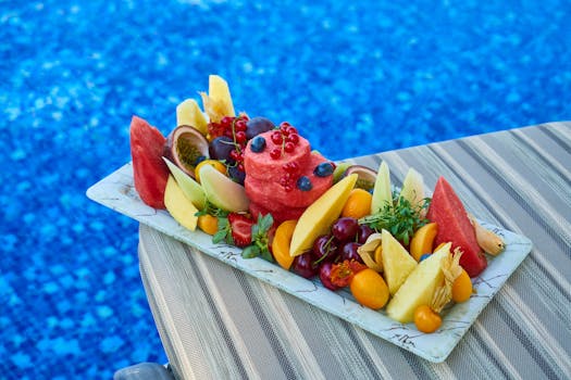 蓝色泳池旁，充满活力的热带水果拼盘搭配着美味佳肴