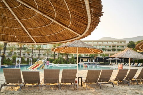 Photo of Sunloungers on Sand Near Swimming Pool