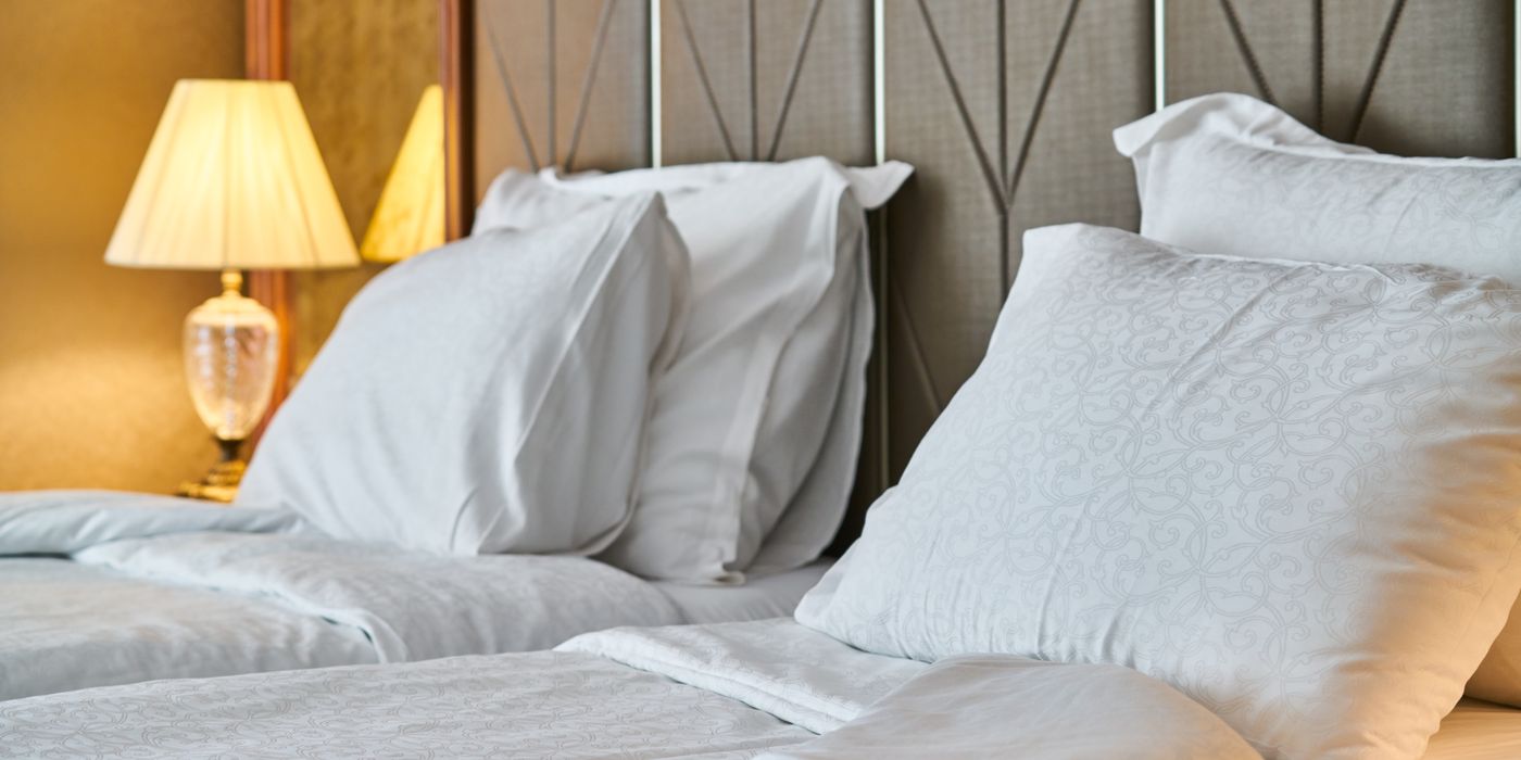 Hotel room with comfortable bedding and warm ambient bedside lighting