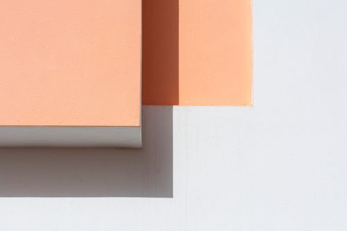 Free Elegant minimalist composition featuring peach and white geometric wall sections with contrasting shadows. Stock Photo