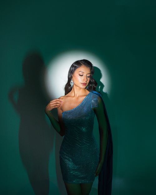 Free Glamorous woman in a sparkling blue dress posing with elegant lighting and shadow. Stock Photo