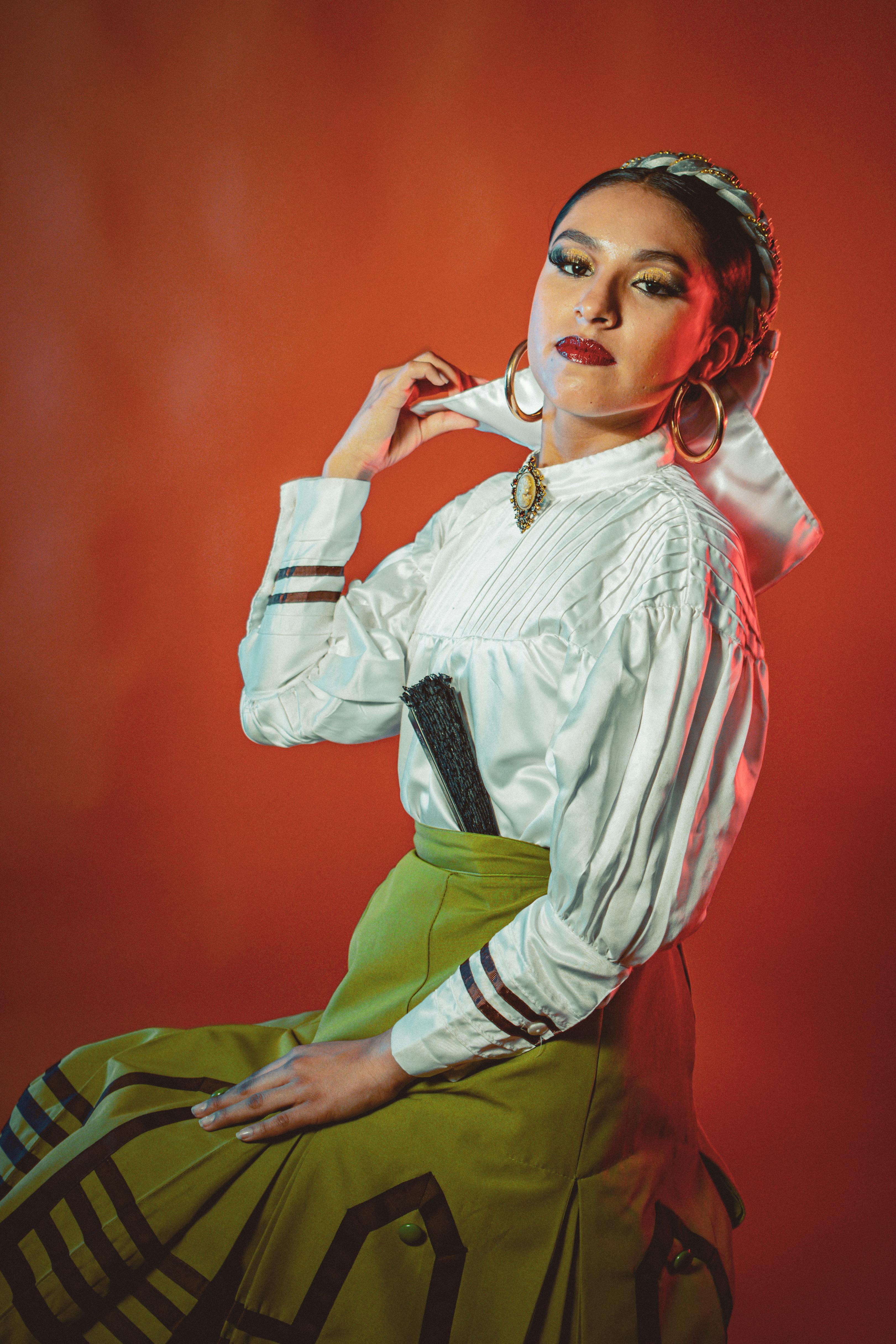 a woman in a skirt and green shirt posing