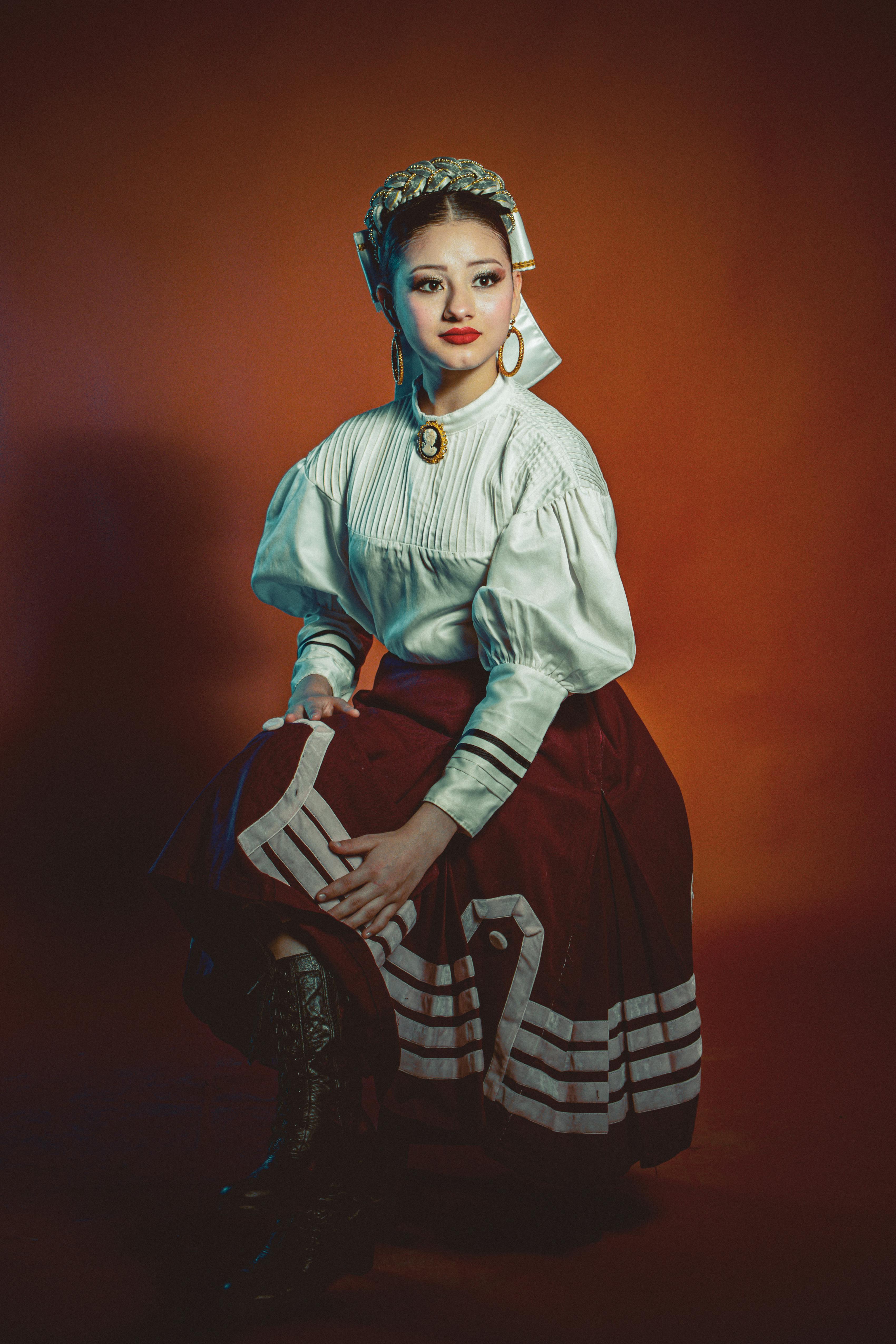 a woman in a red and white dress is posing