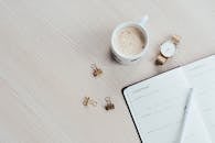 办公桌上布置着咖啡杯、笔记本、笔和手表，风格极简