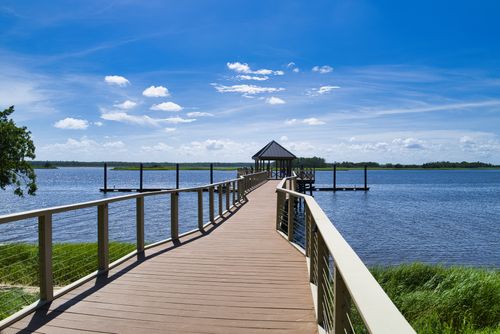 Free Explore the serene pier over calm lake waters under a clear blue sky in Wilmington, NC. Stock Photo