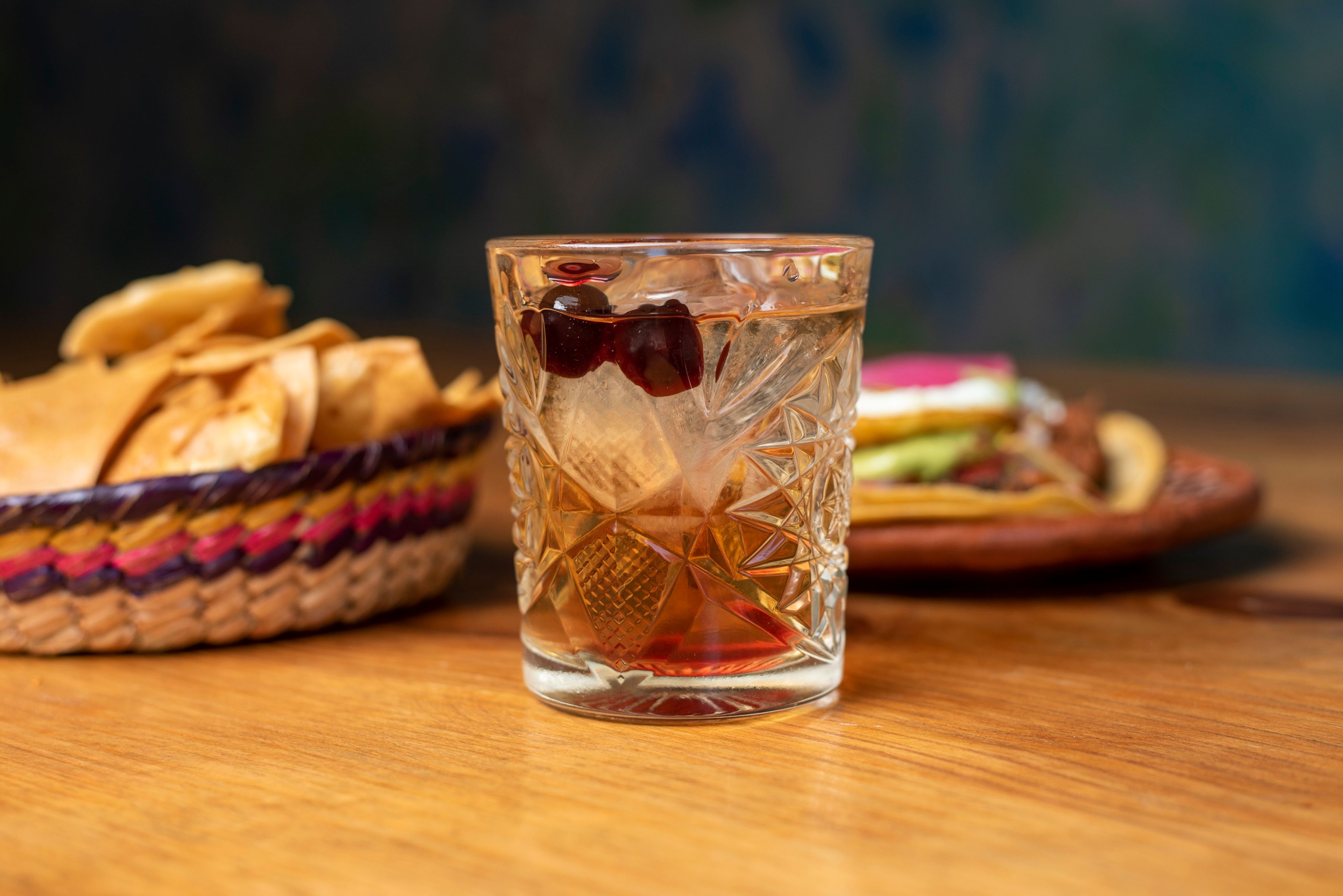 Vibrant Mexican drink with snacks on a rustic wooden table in San Francisco.