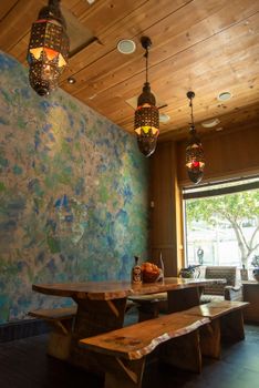 Cozy indoor dining area with rustic wood furniture and Moroccan lamps in San Francisco.