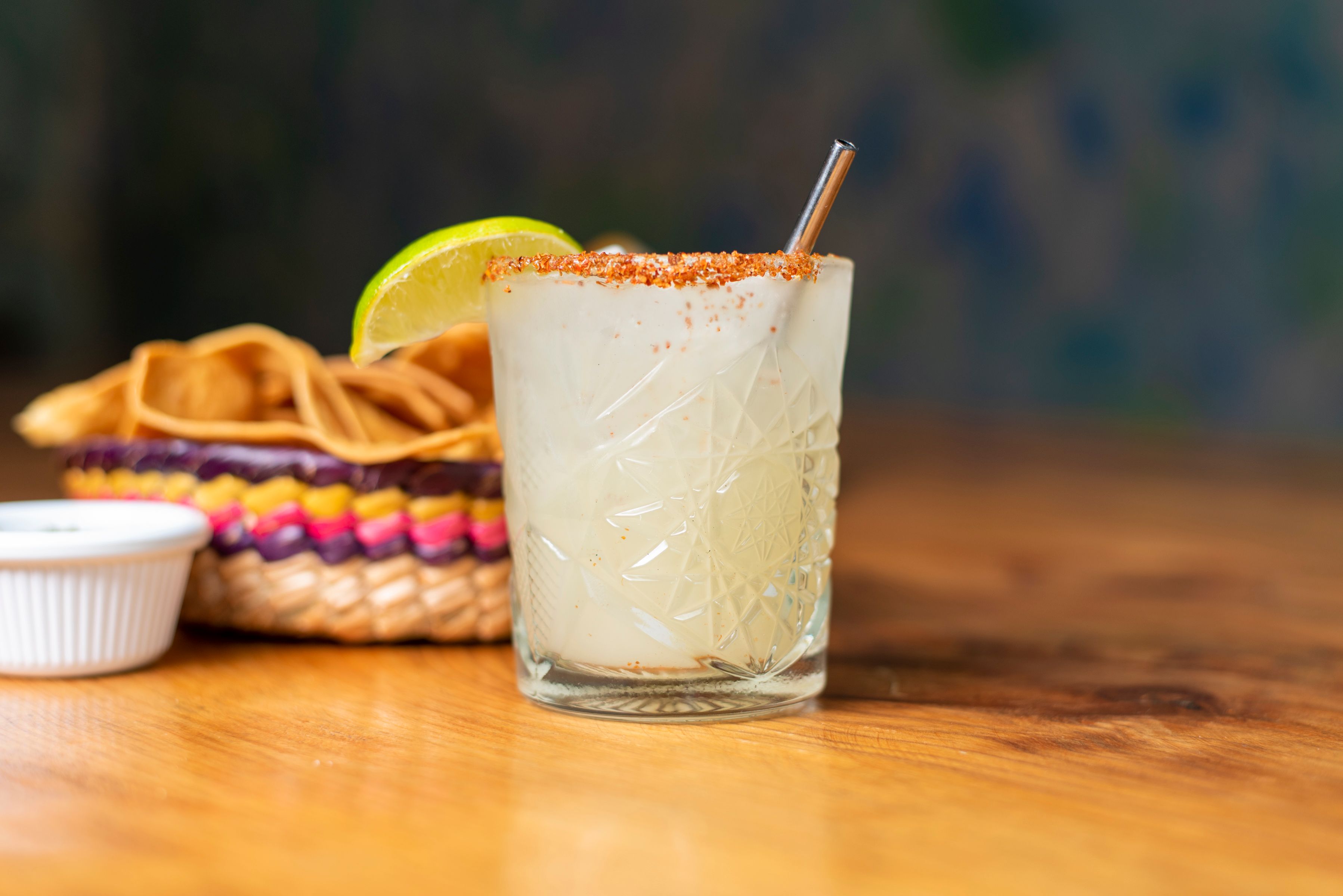 Refreshing margarita with lime wedge on a wooden bar