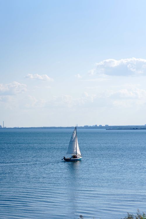 Free A peaceful sailboat gliding on Lake Ontario's calm waters on a sunny day in Toronto. Stock Photo