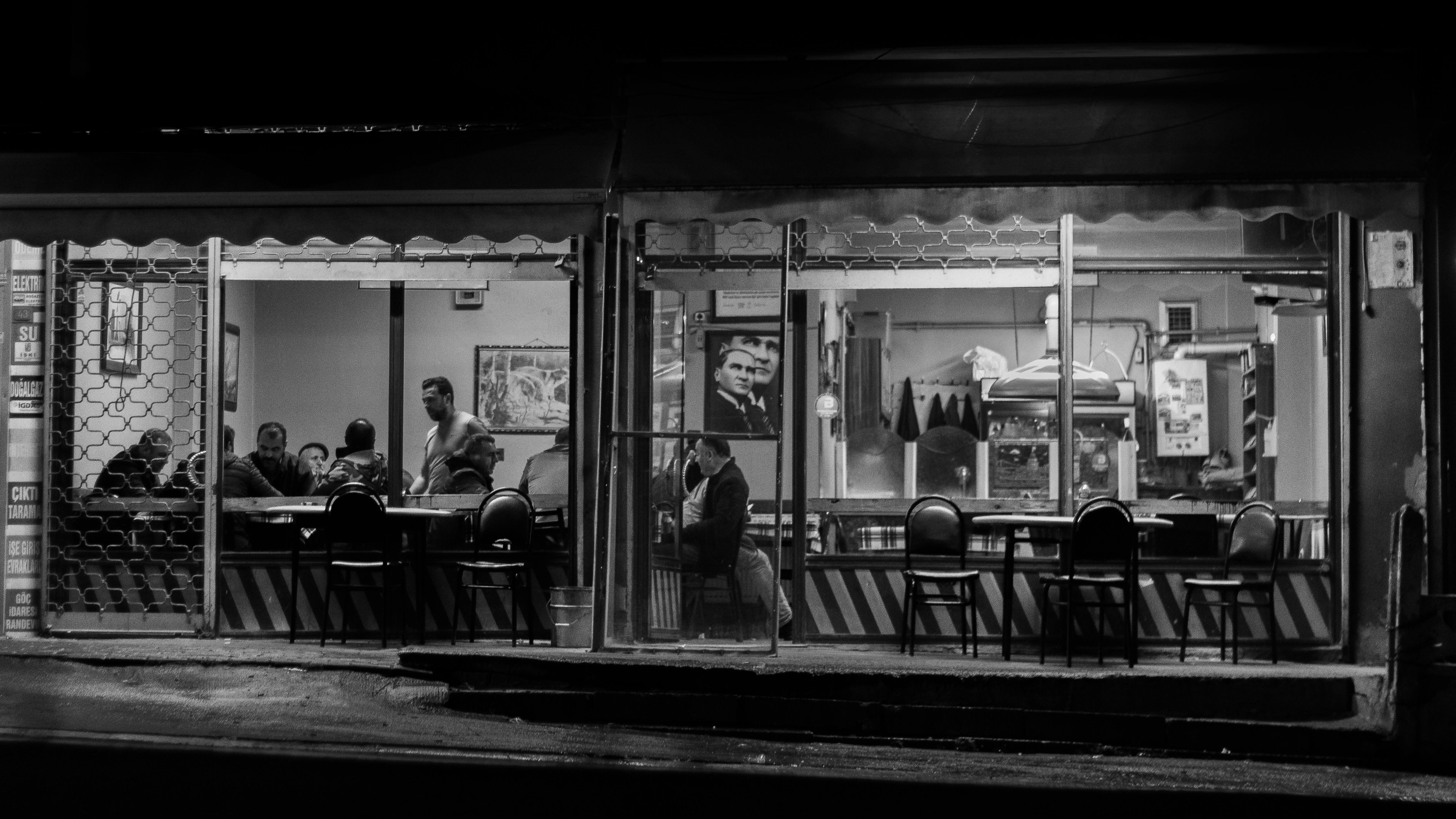 Ücretsiz Gece vakti İstanbul'da şirin bir kafede oturan insanların siyah beyaz fotoğrafı. Stok Fotoğraflar