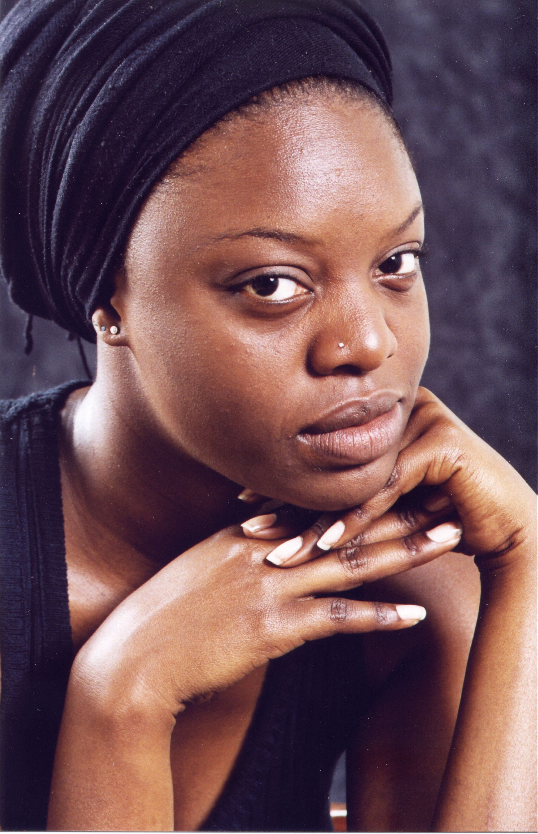 Striking portrait of a woman with thoughtful expression and elegant jewelry. Perfect for fashion and lifestyle themes.