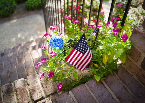 A vibrant flower pot with American flags, capturing the spirit of summer in Wilmington, NC.