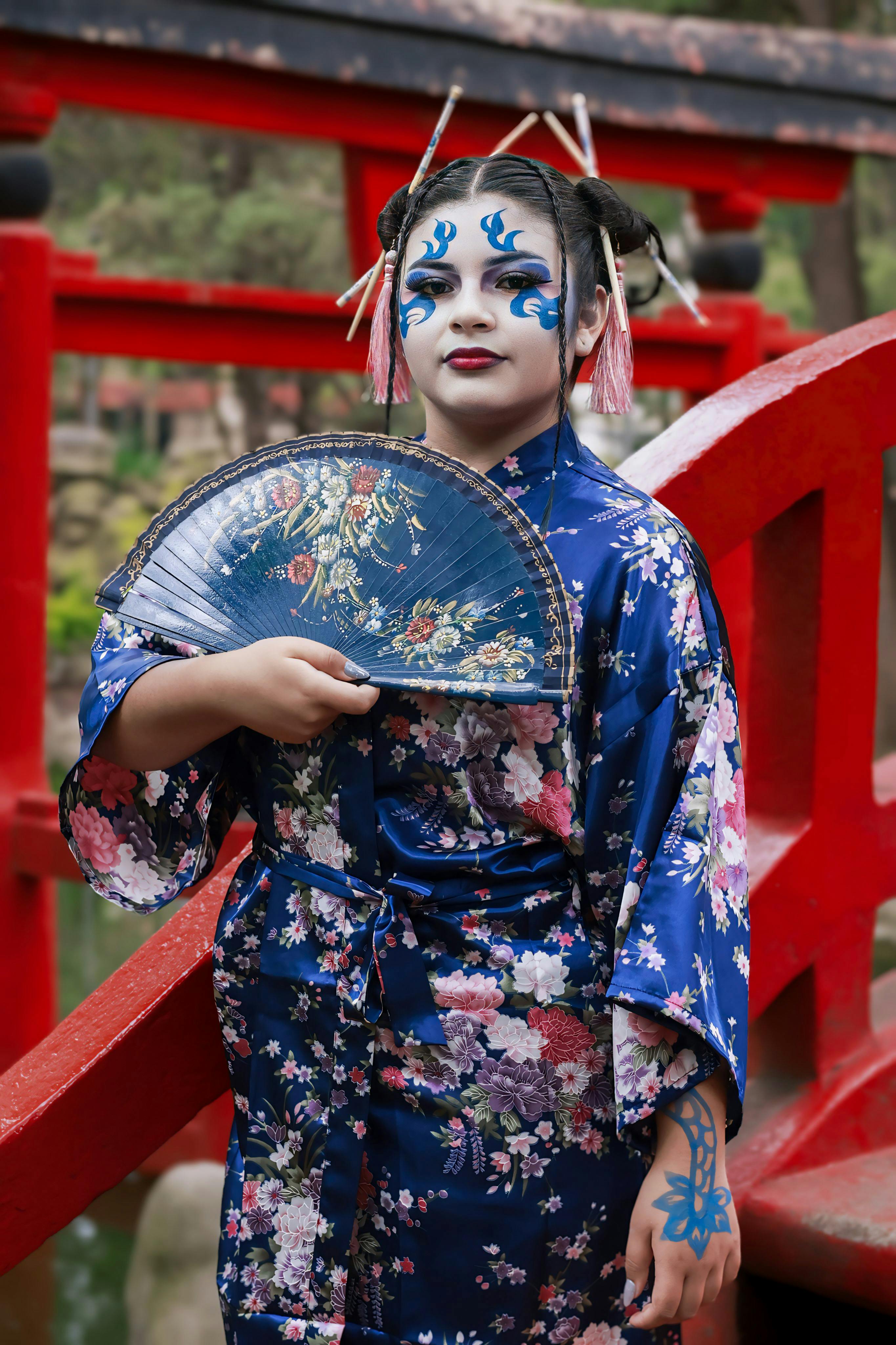 a woman in a geisha costume holding a fan