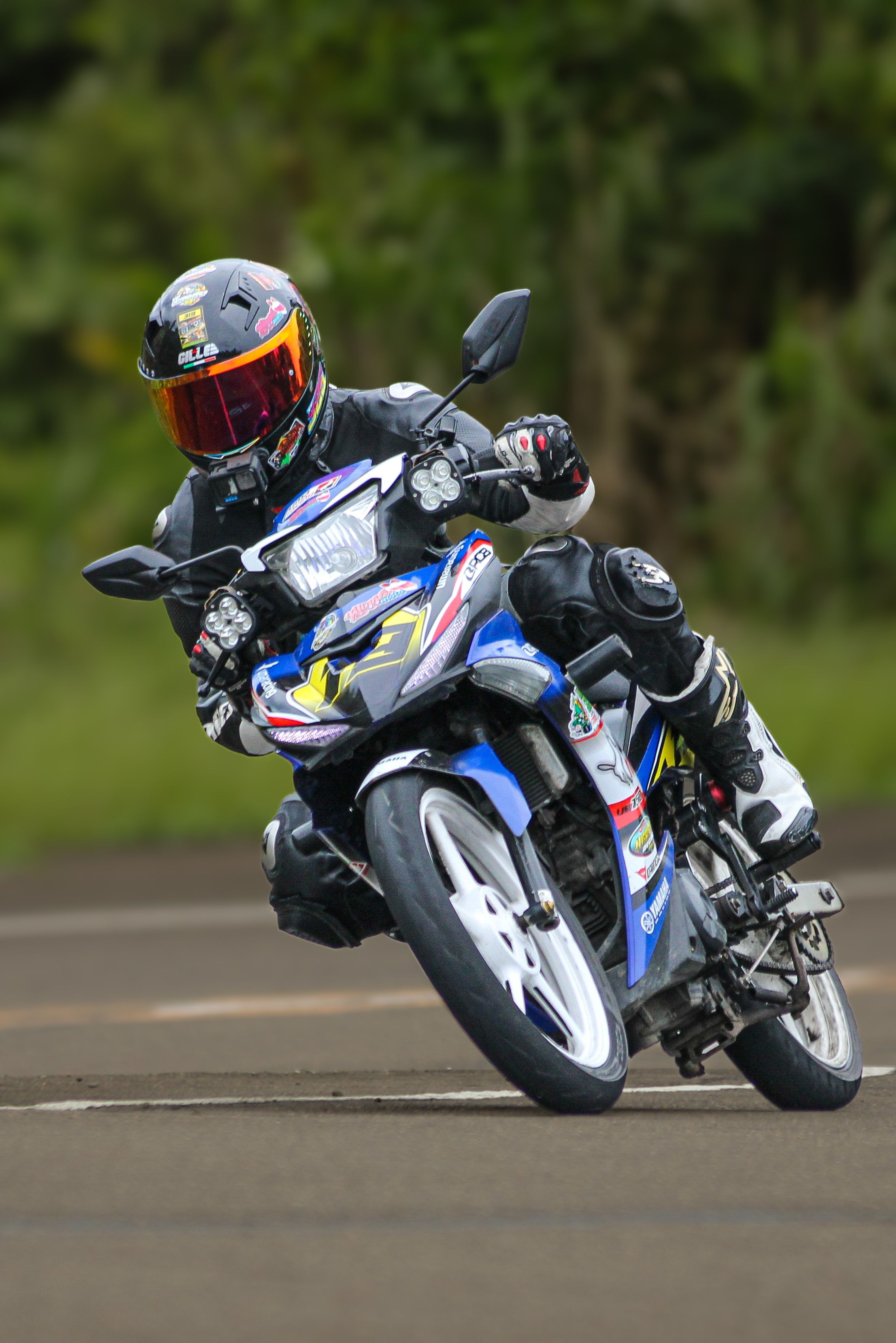 Professional motorcycle racer leaning into a corner on a track during a high-speed race.