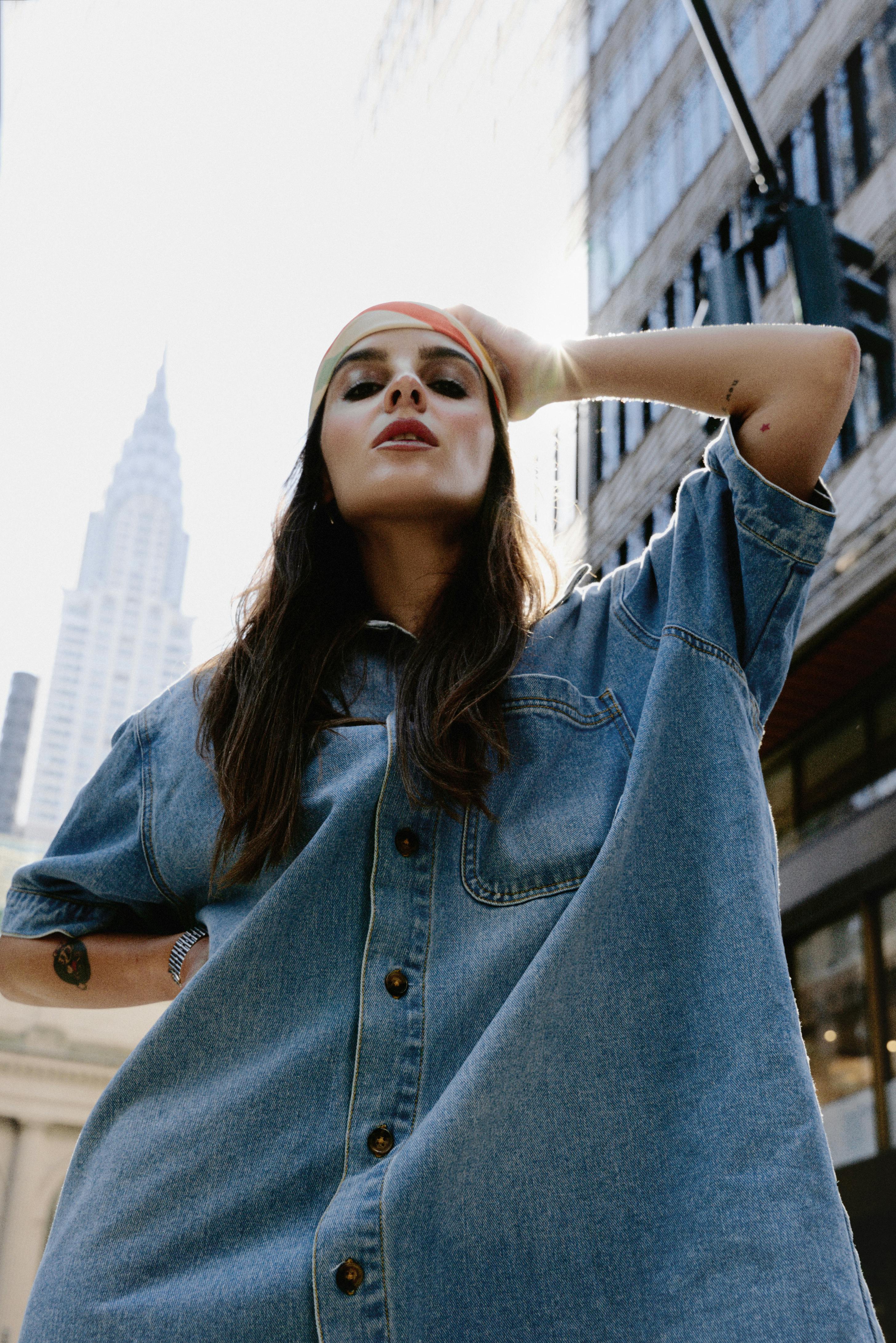 a woman in a denim shirt dress and hat