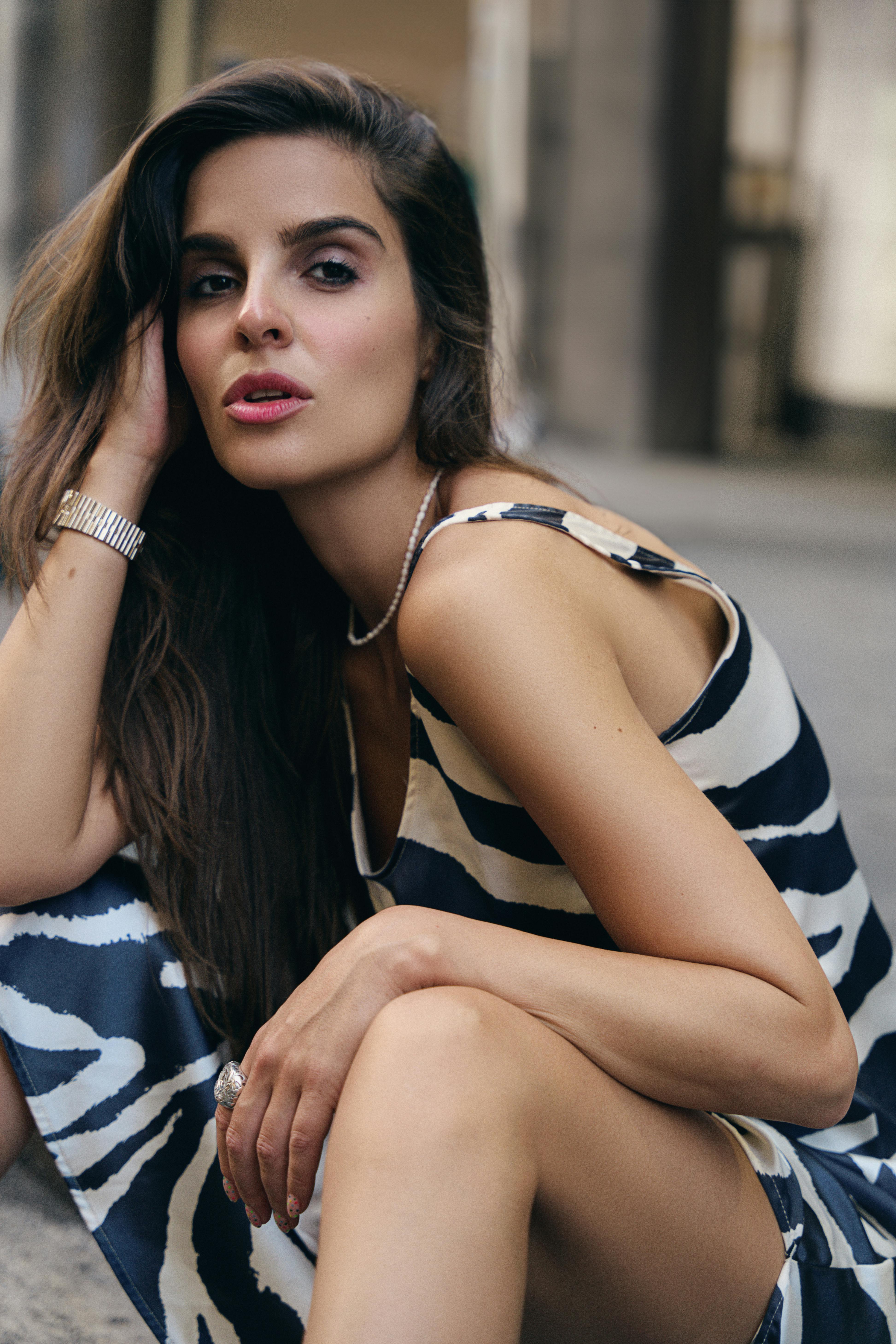 a woman in a striped dress sitting on the ground