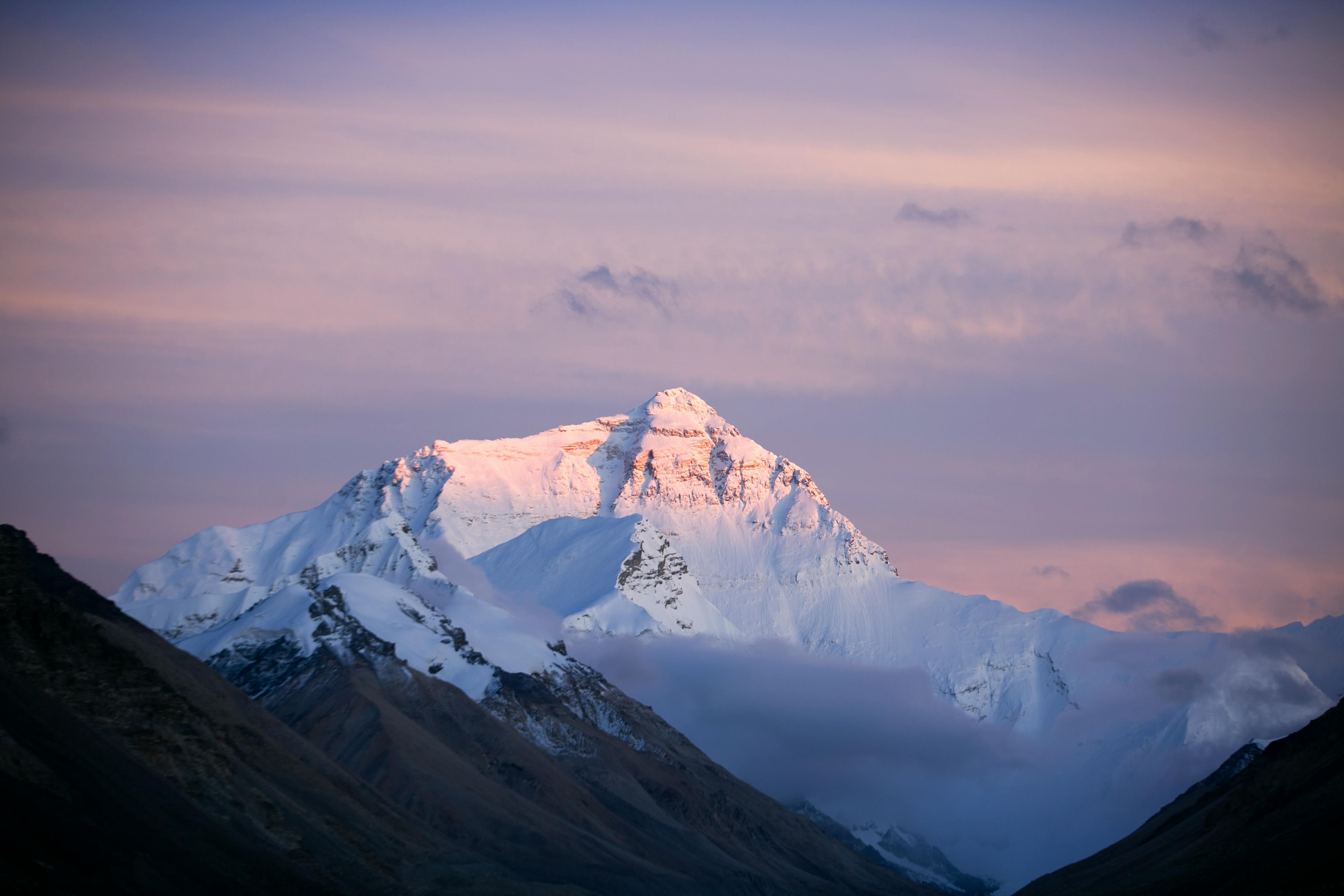 Dramatic view of Mount Everest at sunset, capturing its majestic snow-capped peaks and surrounding landscape.