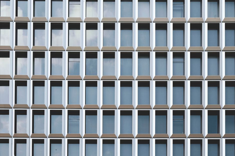 A striking modern facade showcasing a pattern of repetitive glass windows under daylight.