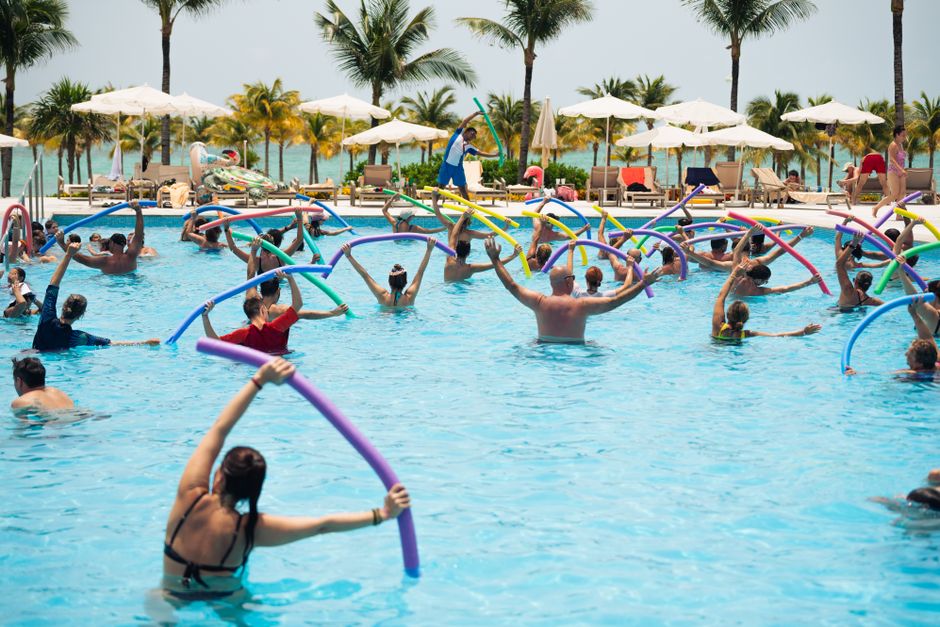 A senior performing gentle water aerobics in a community pool A senior performing gentle water aerobics in a community pool
