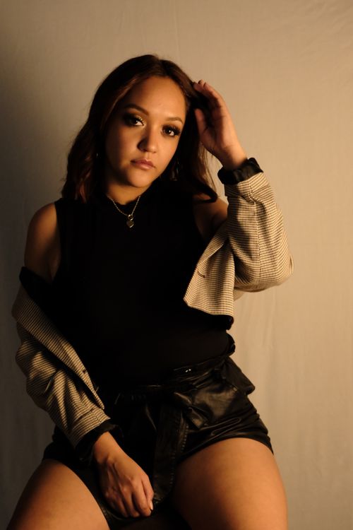 Free Stylish portrait of a young woman in a studio, showcasing modern fashion and elegance. Stock Photo