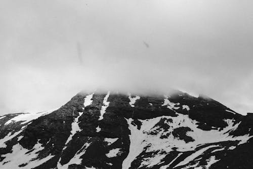 Montaña Cubierta De Nieve Bajo Nubes Blancas